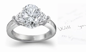 engagement ring with oval diamond center and side heart diamonds